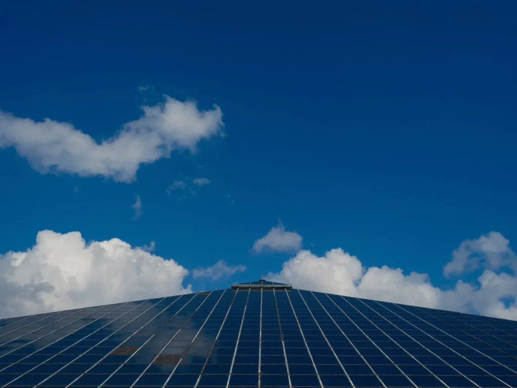 Groot dak vol zonnepanelen onder een blauwe lucht